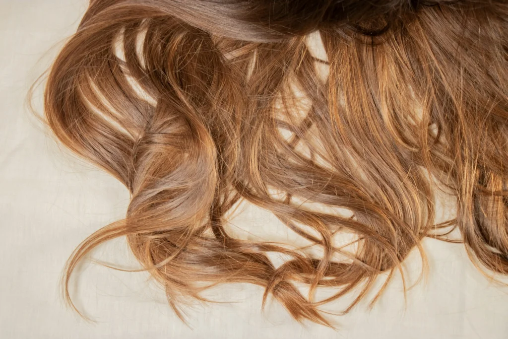 Brown hair on a surface, prone to hair breakage