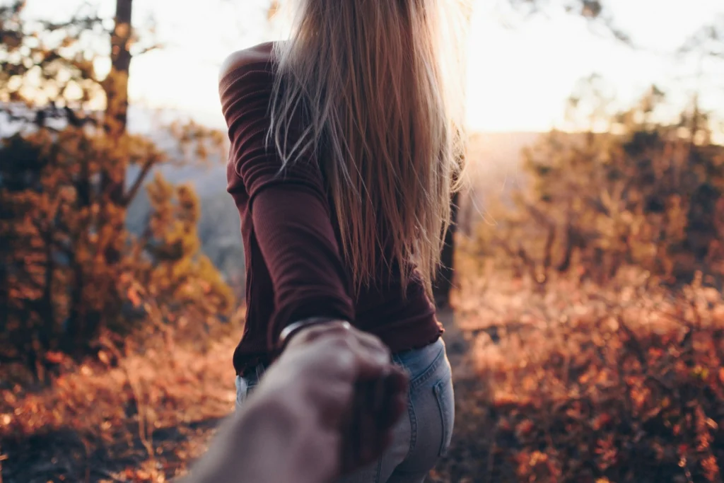 woman holding hands with someone seen from the back