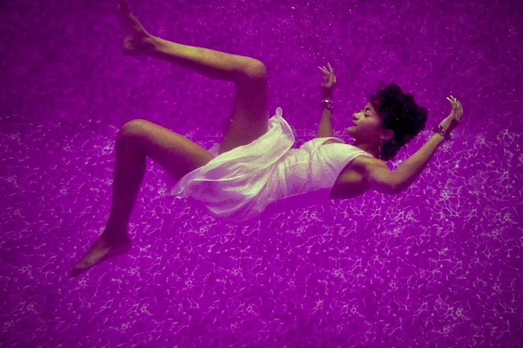 woman in white floating in purple liquid