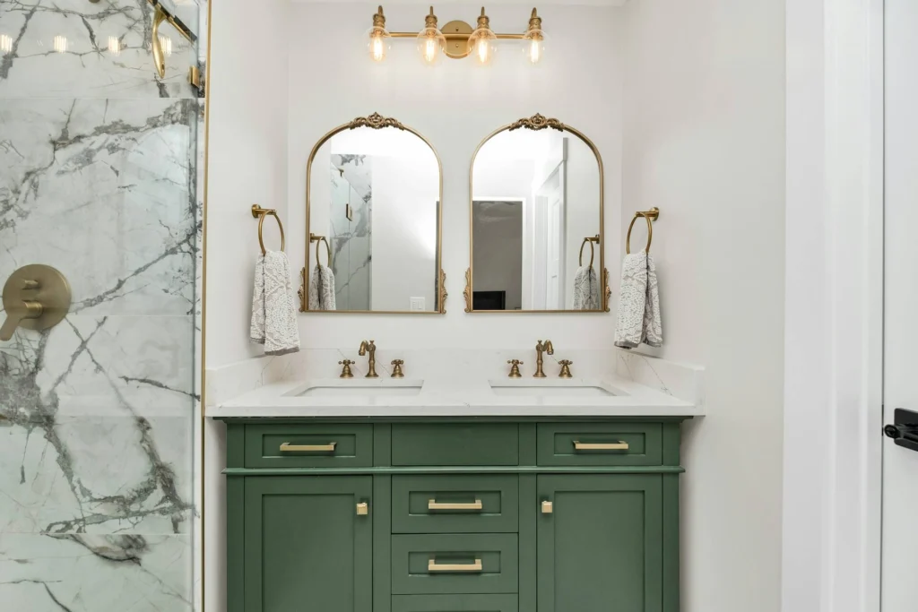 Marble shower, double sinks and gold mirrors in a modern bathroom