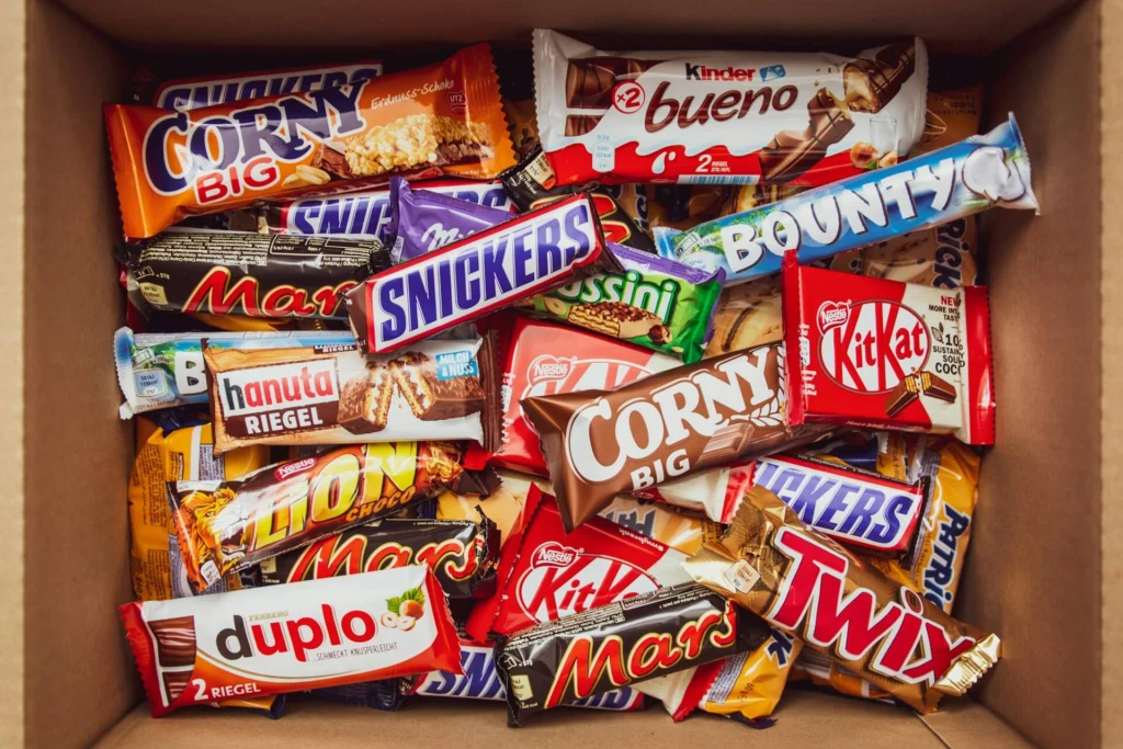 A cardboard box filled with an assortment of chocolate candy bars
