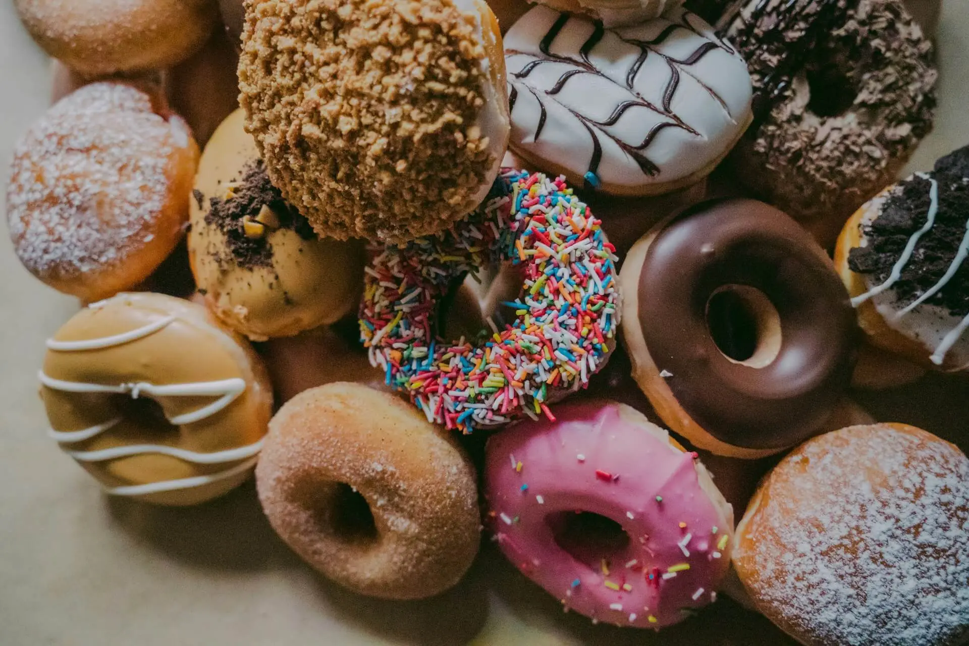An assortment of frosted, sprinkle-topped donuts arranged together