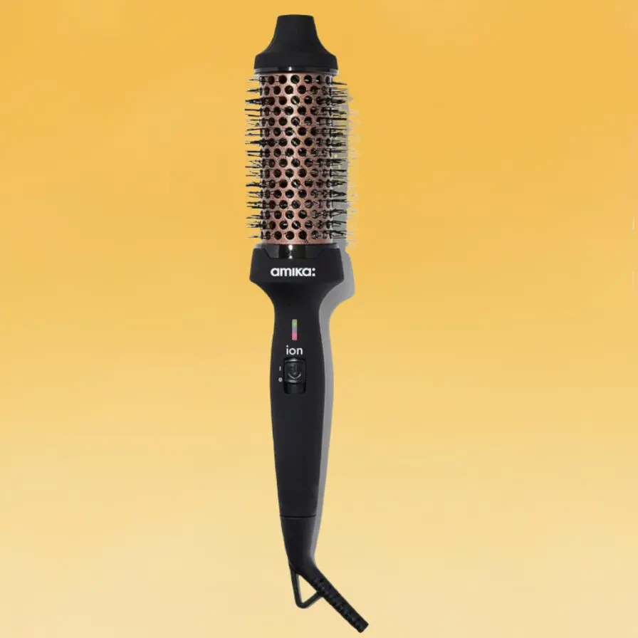 A cylindrical Amika thermal brush with a black handle and a copper round brush.