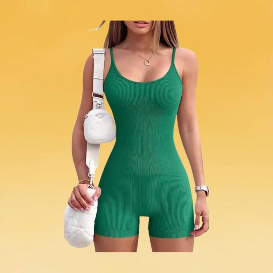 A woman wearing a green fitness romper and holding a white shoulder bag