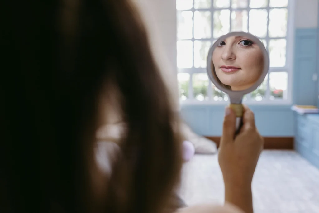 a woman looking at herself in the mirror