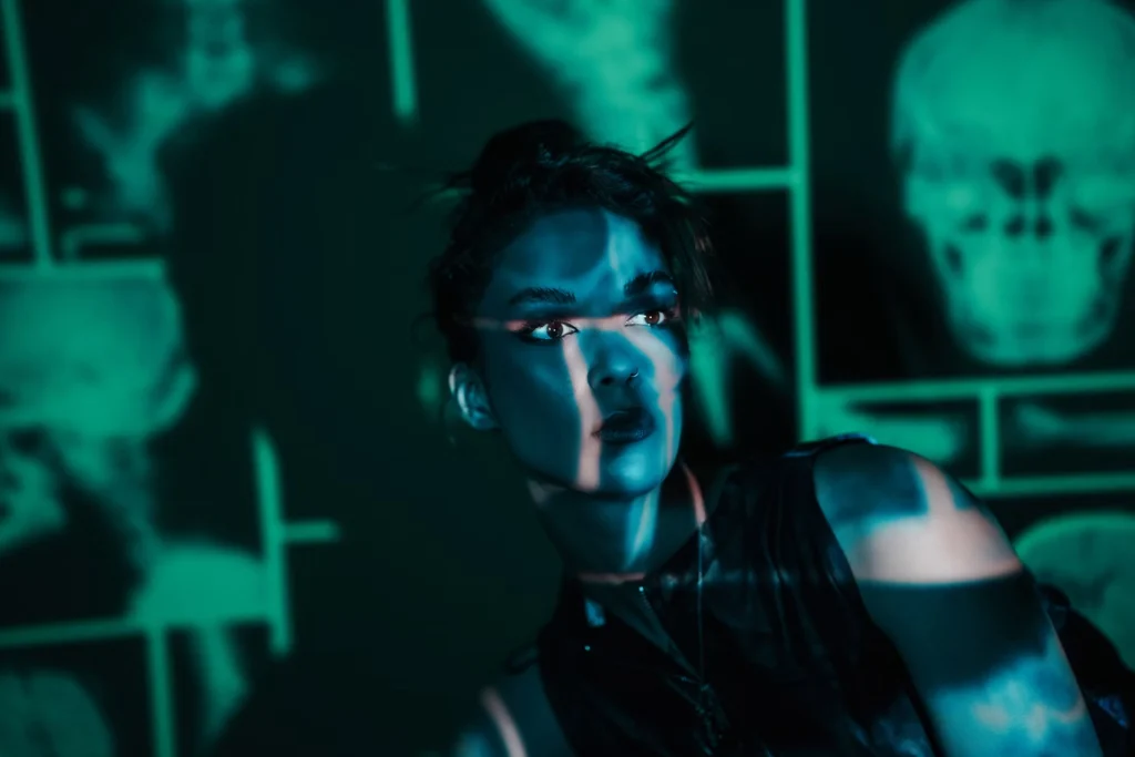 woman in shadow wearing black with green background