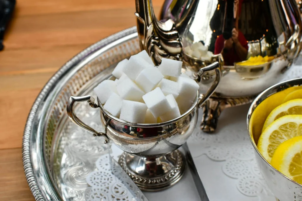A clear tray holding a teapot and a bowl of sugar cubes