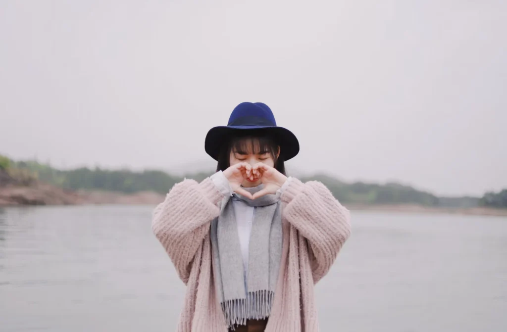 girl making a heart sign