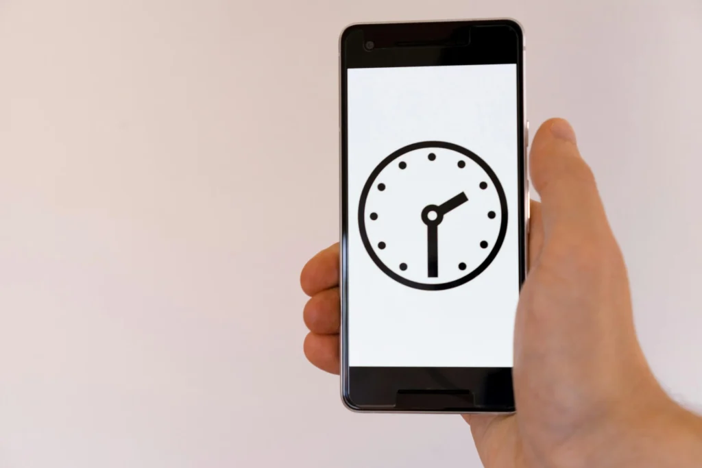 A smart phone with a clock on the screen