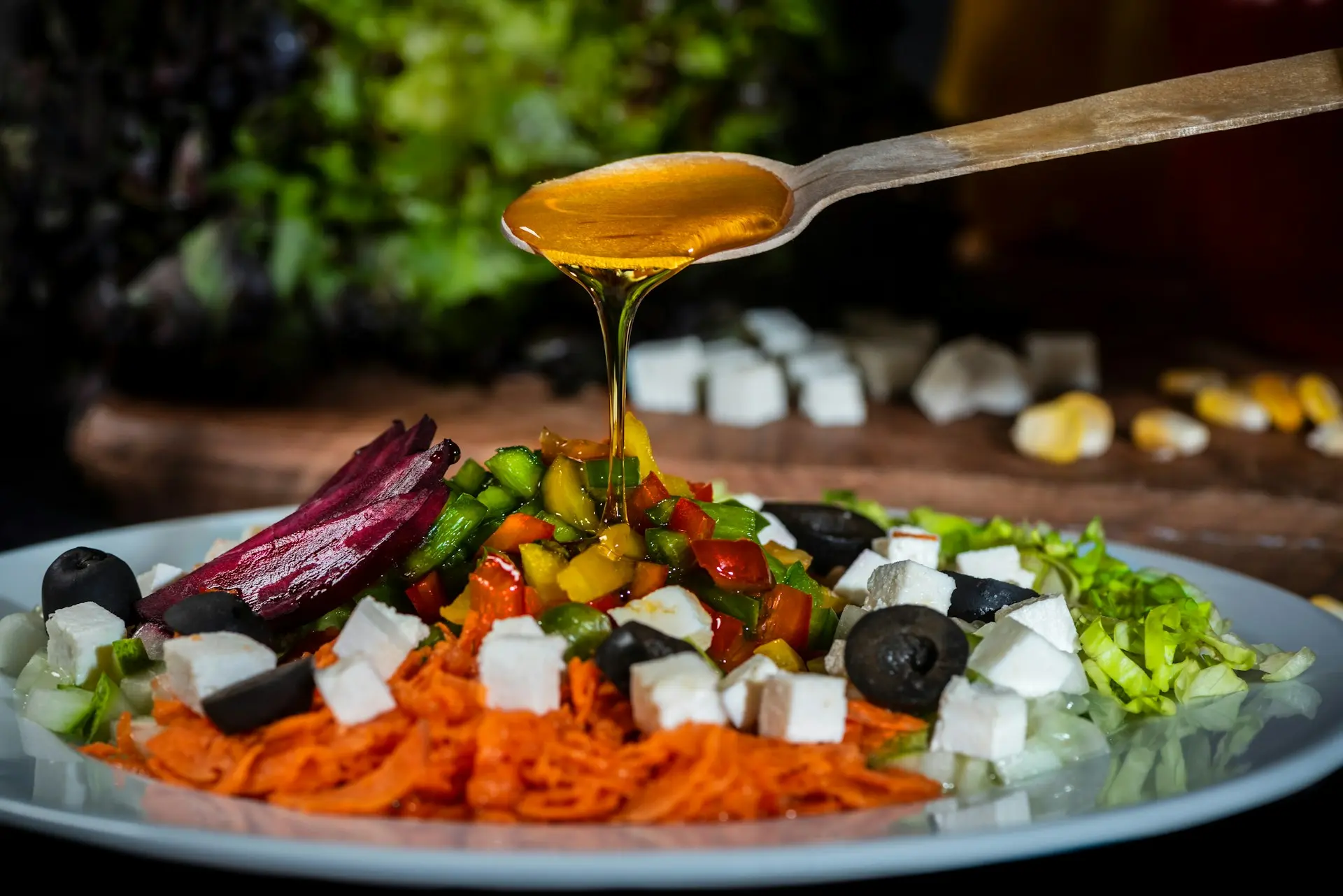 Pouring vegetable oil over a plate of salad