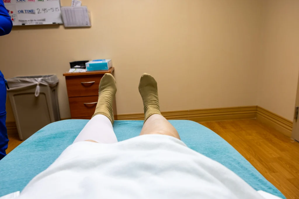 Patient resting on a bed while receiving dermatology care