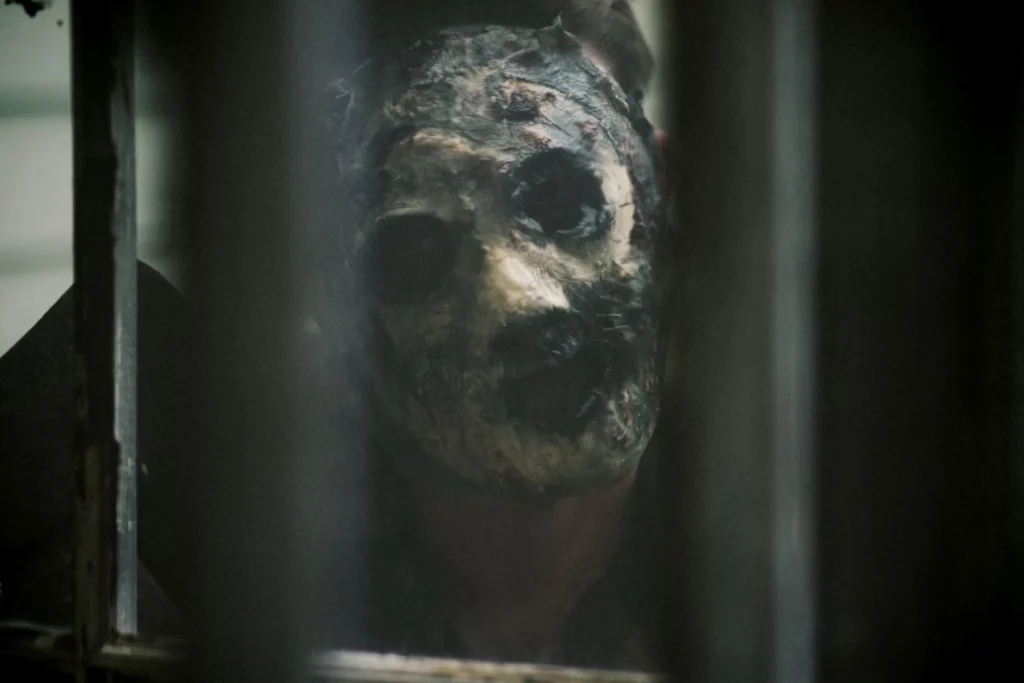 zombie looking through bars on window