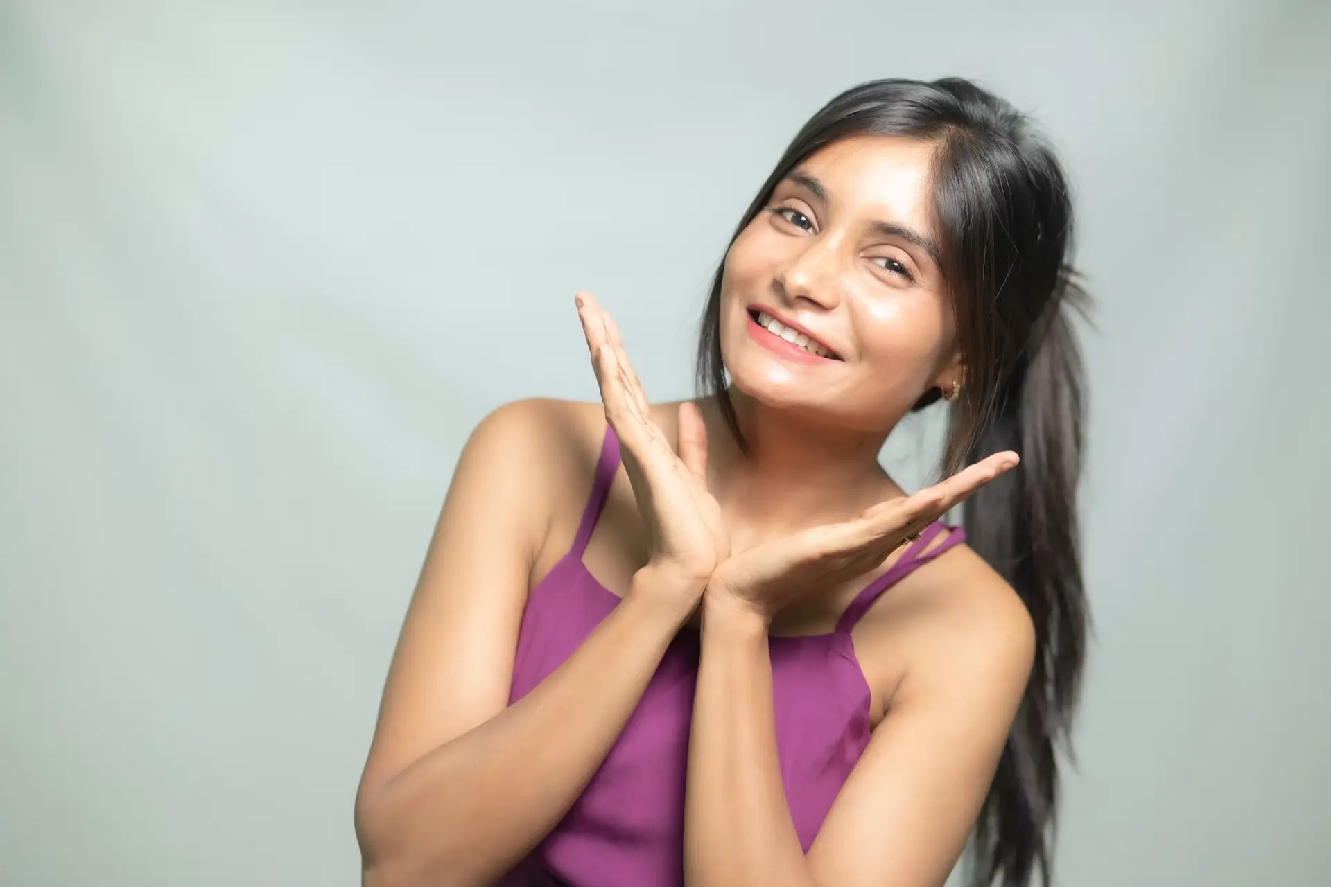woman in pink joining hands and smiling