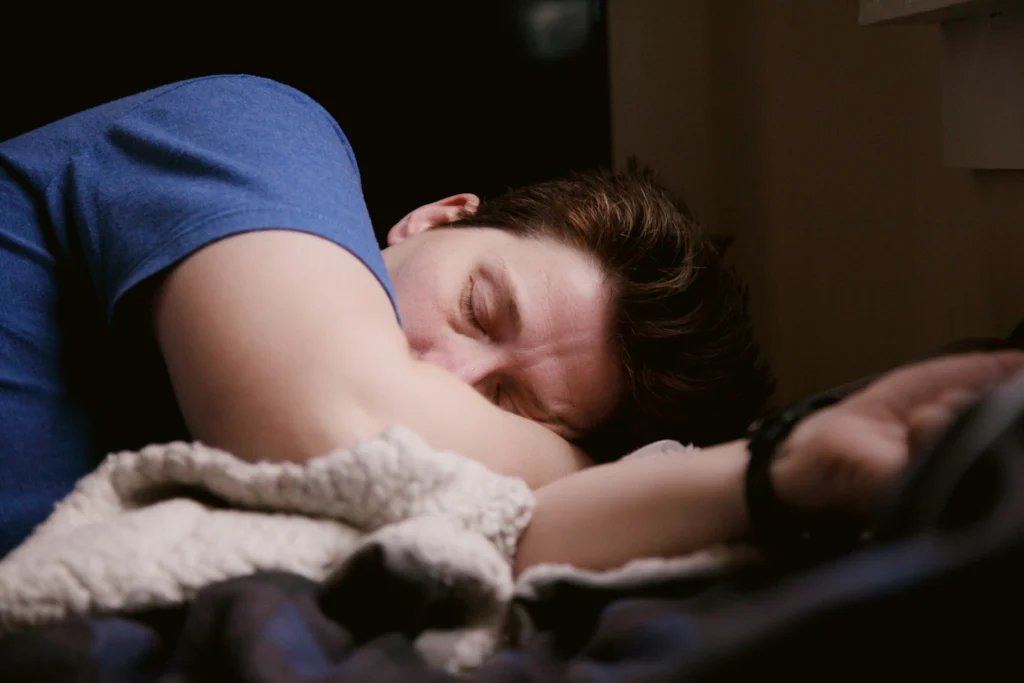 A man closing his eyes, likely tired due to sleep debt