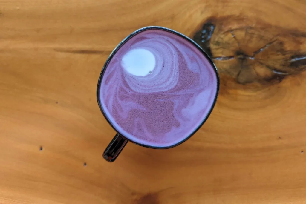 a cup of ube latte colored purple and white