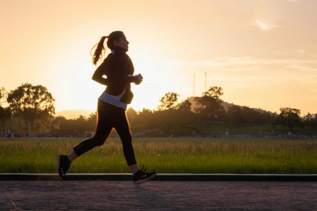 A woman running at sunset.