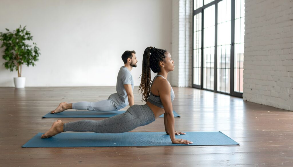 Man and woman doing upward-facing dog yoga pose