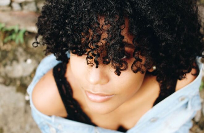 woman with natural hair using water-based leave-in conditioner