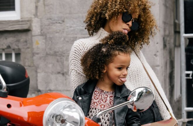 a mother and toddler on a motorcycle ready to try temporary hair color for kids
