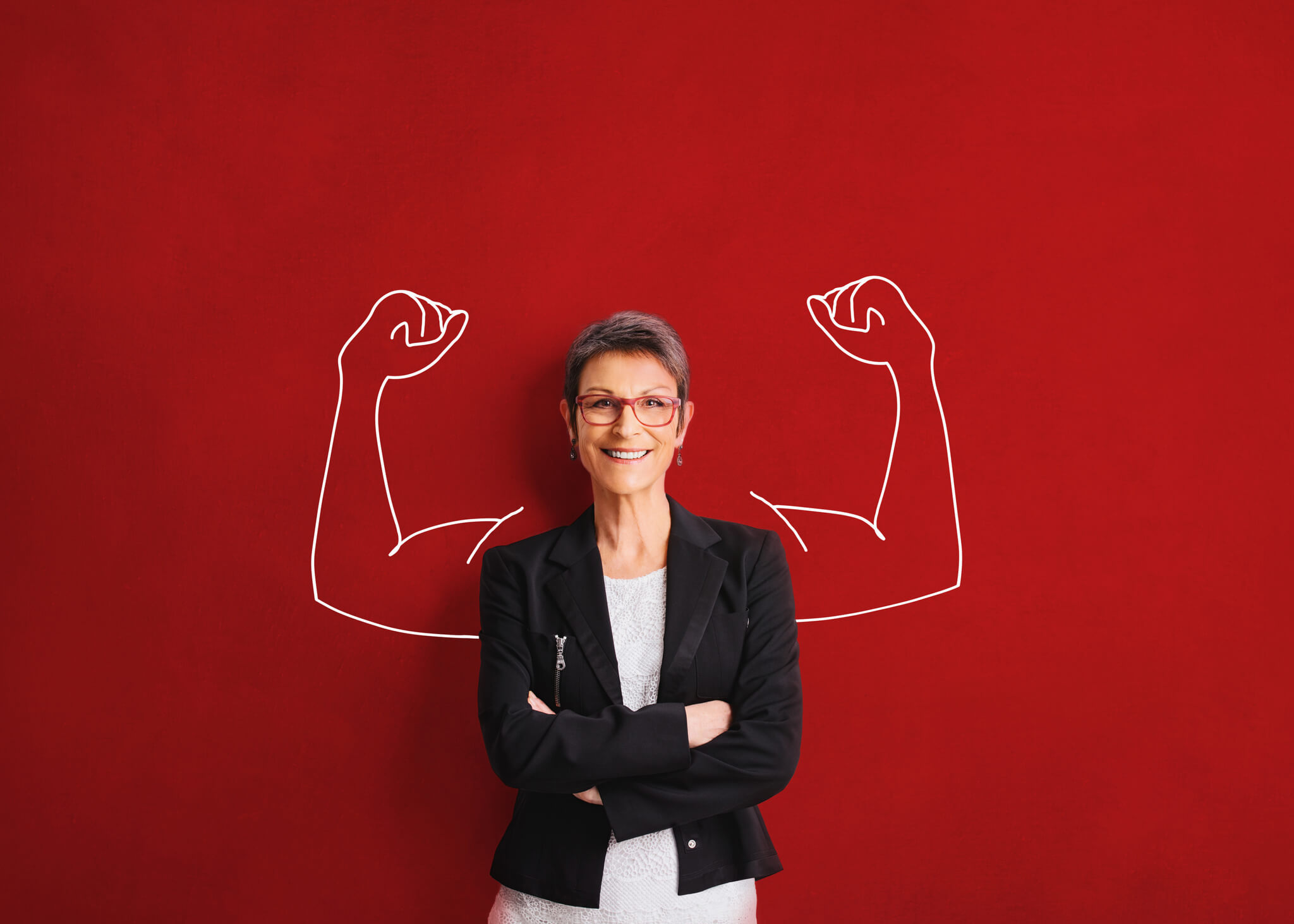 woman standing in front of red wall with drawing of flexing arms behind her
