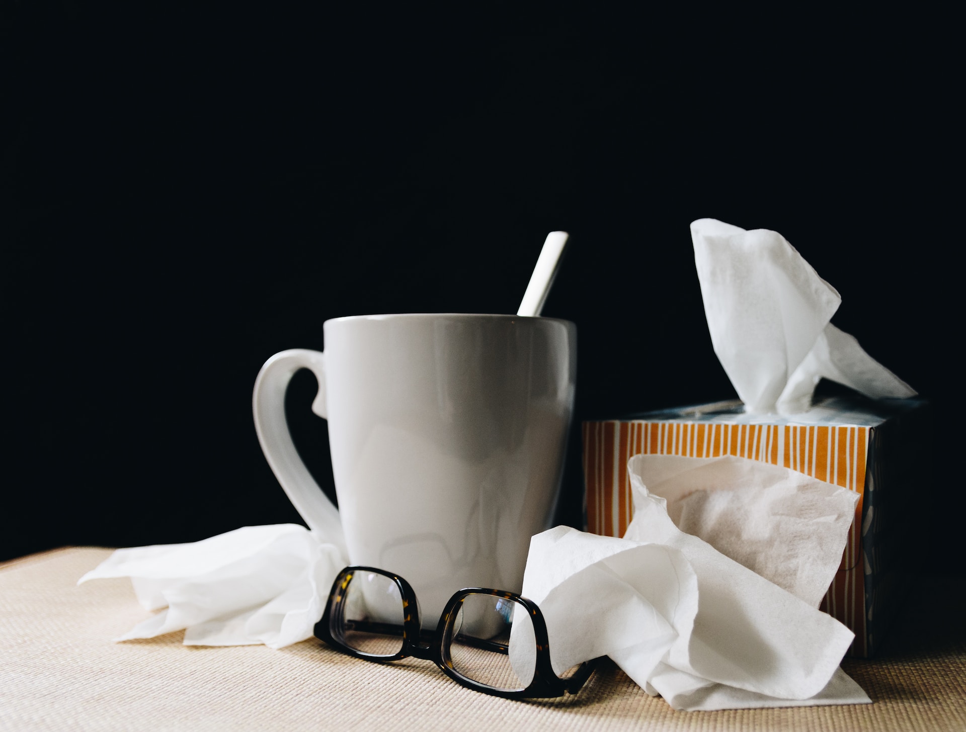 how to recover from the flu - a box of open tissue, a mug and eyeglasses