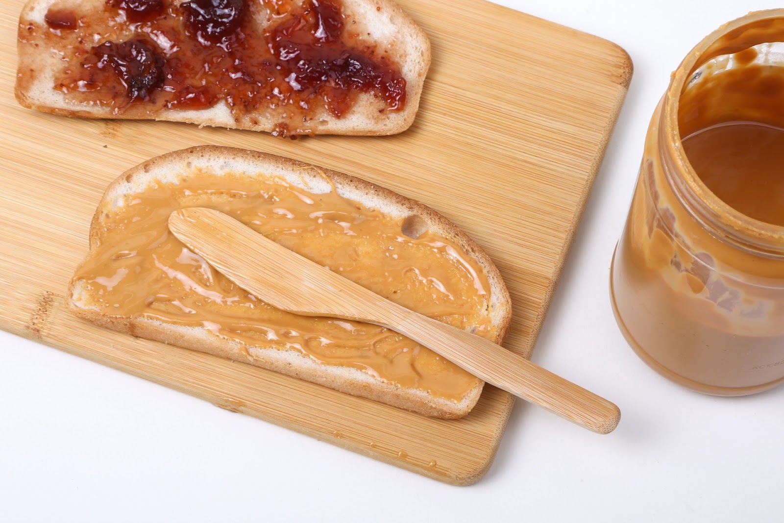 Two bread slices, one with jam and one with peanut butter - breakfast ideas without eggs