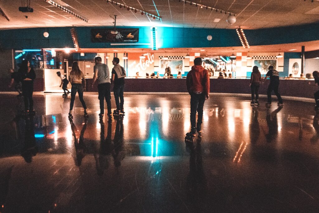 A group of young people rollerblading indoors
