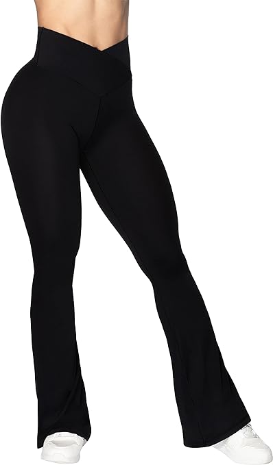 A woman stands in white tennis shoes and black leggings that flare at the bottom an have a v-shaped, high-waist.