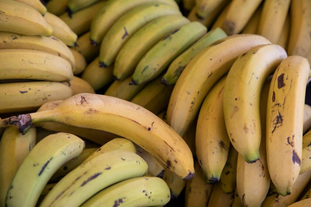 Yellow and green bananas pilled on top of each other.