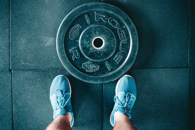 A weightlifter's shoes next to a weight
