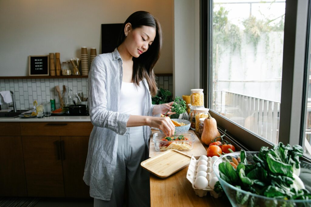 A woman adding food to a storage container