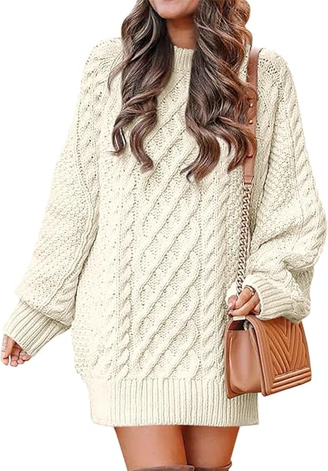 A woman with brown curly hair wears a chunky-knit oversized sweater dress and a brown purse as one of the best first date outfit ideas for a woman.