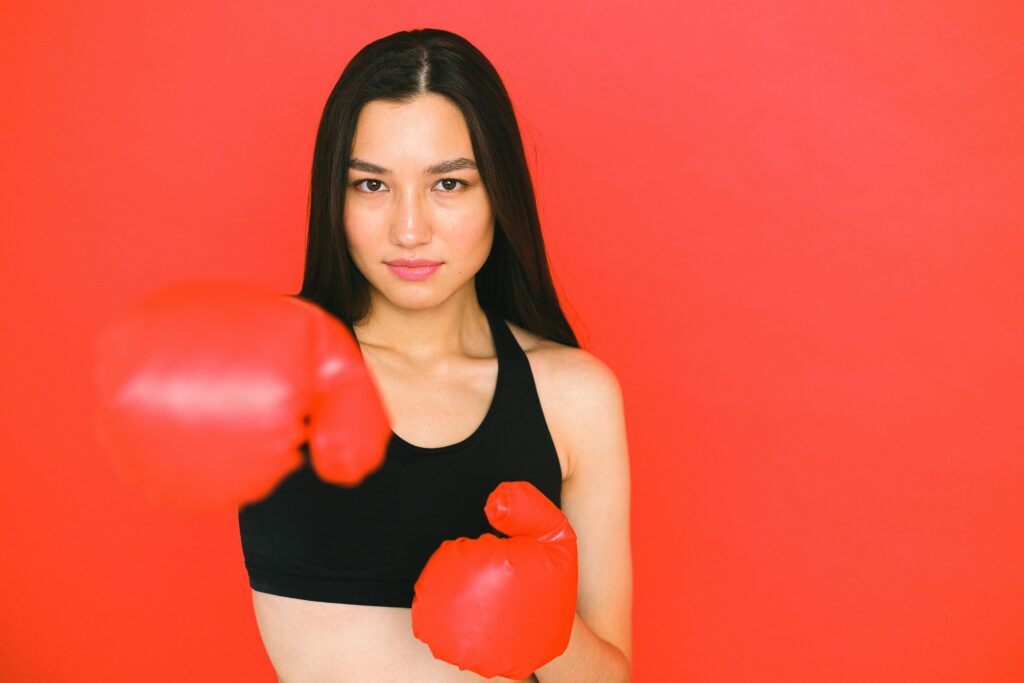 A girl wearing a reversible sports bra and boxing gloves 
