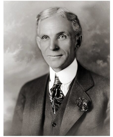 A black and white photo of Henry Ford wearing a suit and tie.