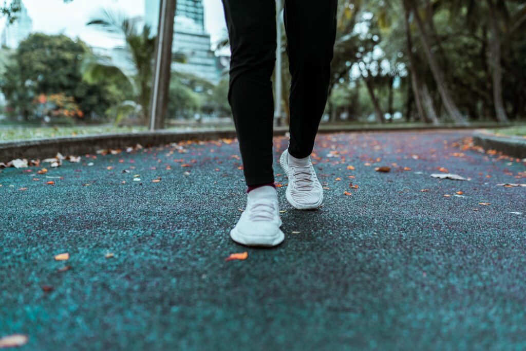 Workout shoes pictured on asphalt with fall leaves in the background