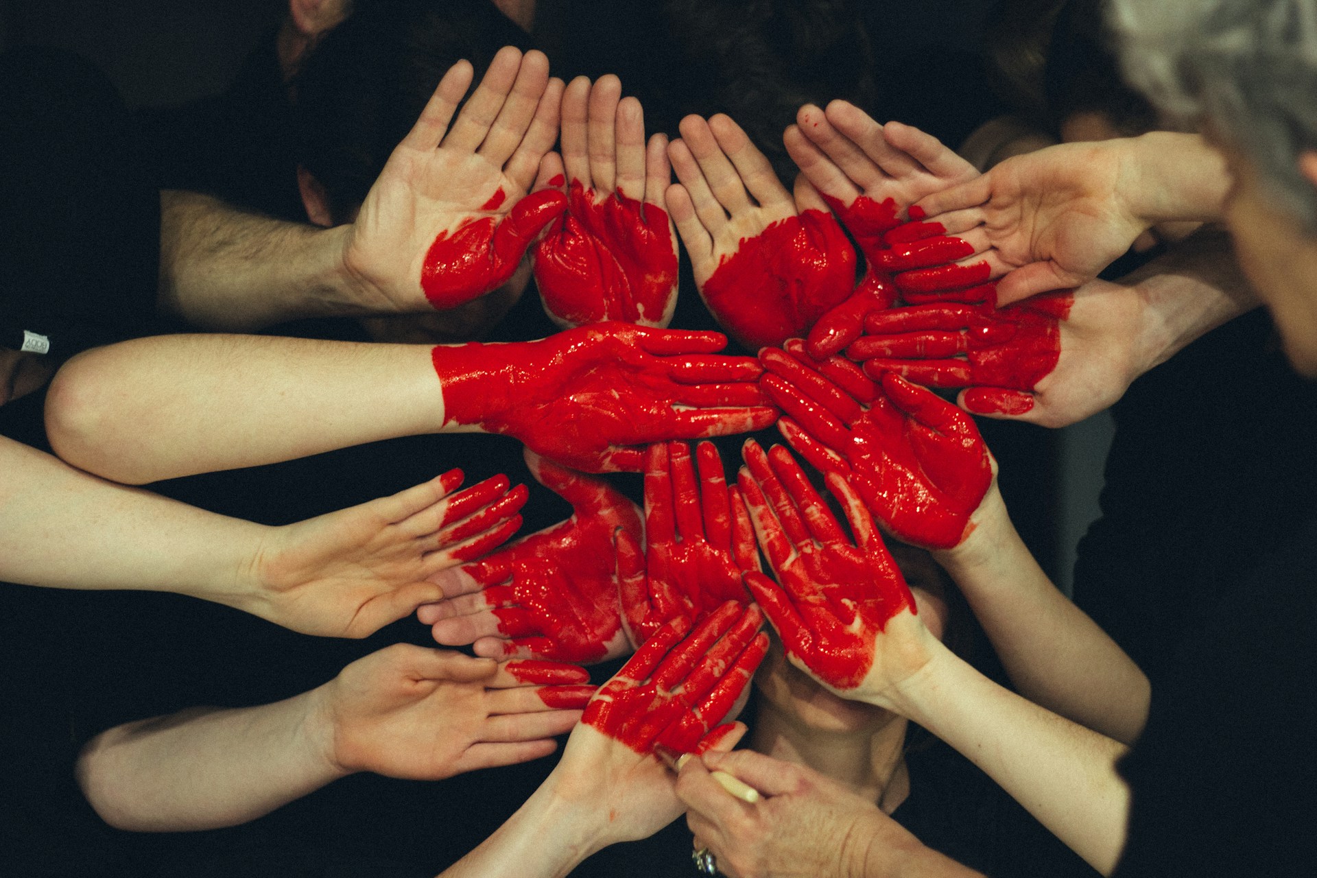 Hands with a red heart painten on them to show non traditional relationship types.