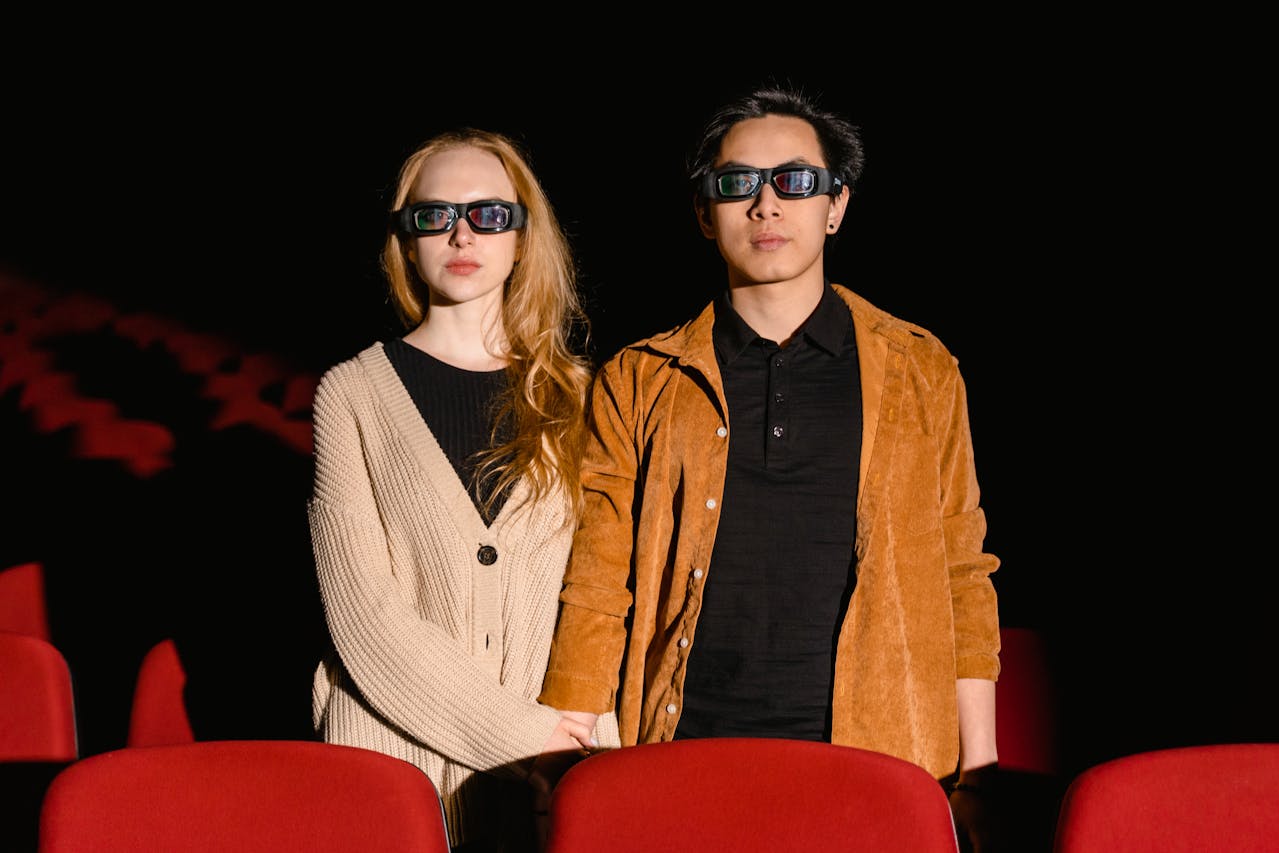 A man and woman wearing 3D glasses in a movie theater