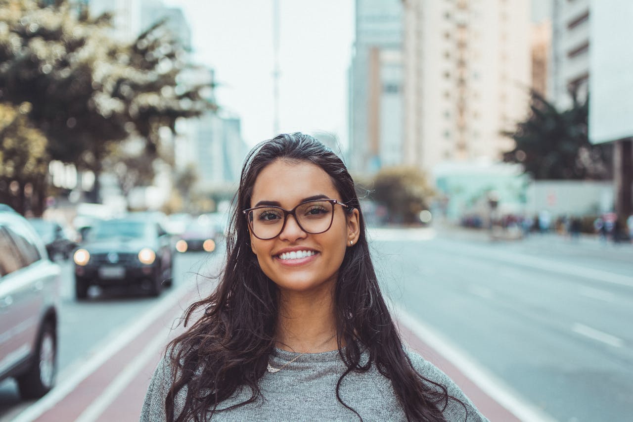 A woman posing and smiling amid a streetscape backdrop