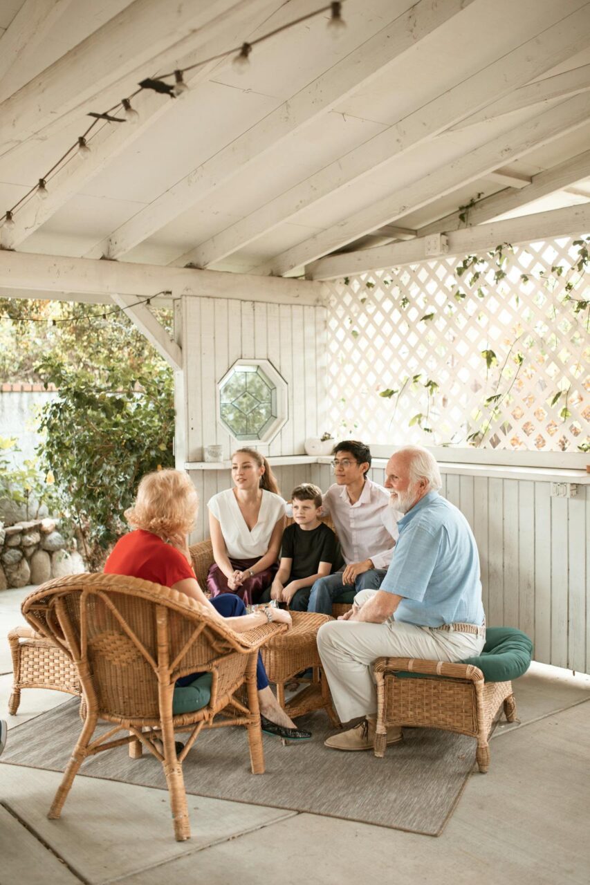 A couple speaking to their elderly parents