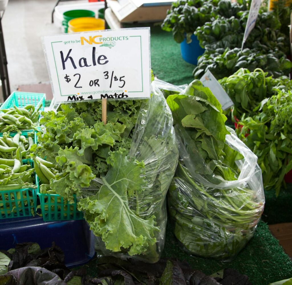 Green leafy vegetables in bags and cartons at a food market