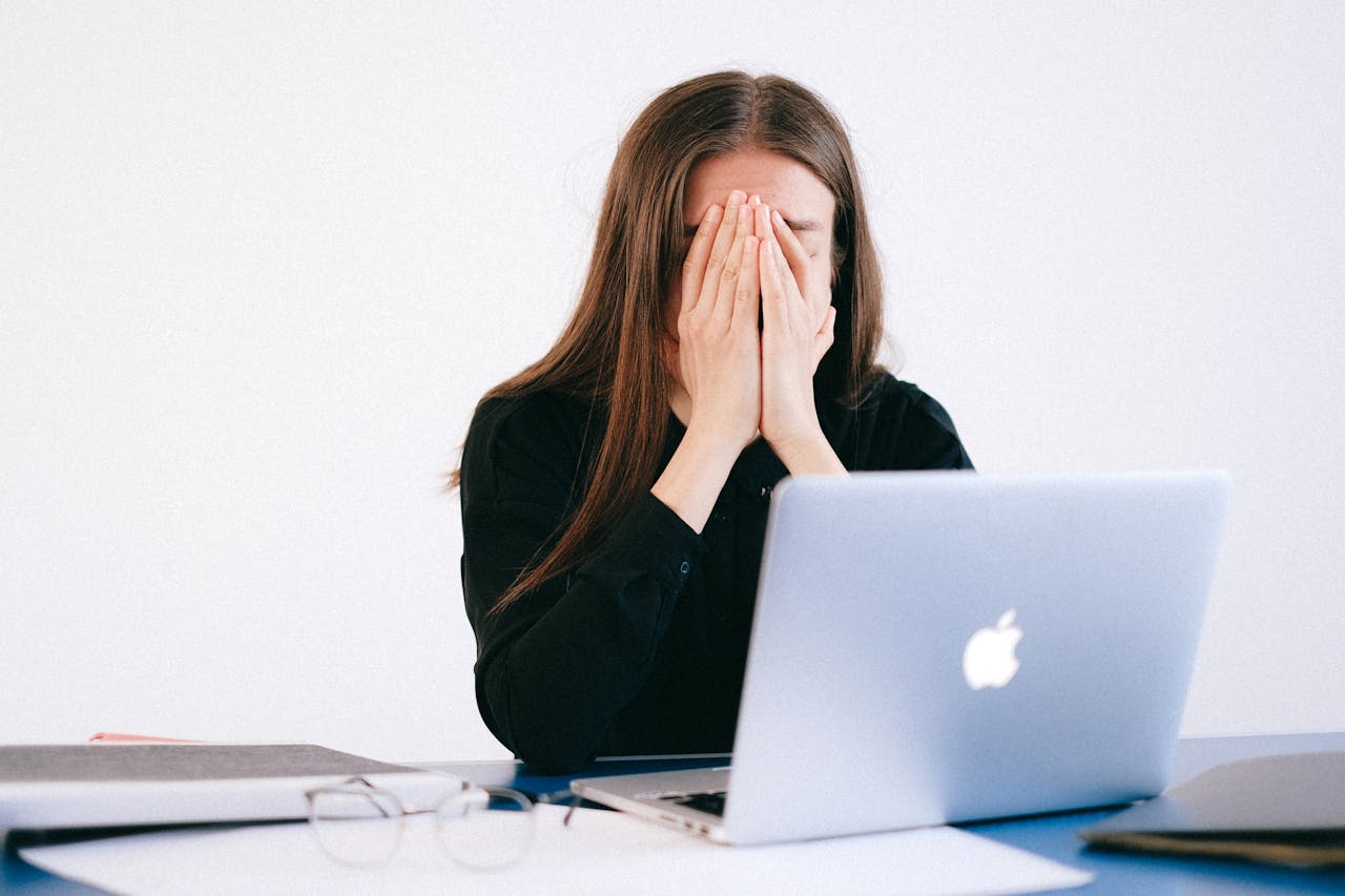 A woman stressed, with her face in her hands