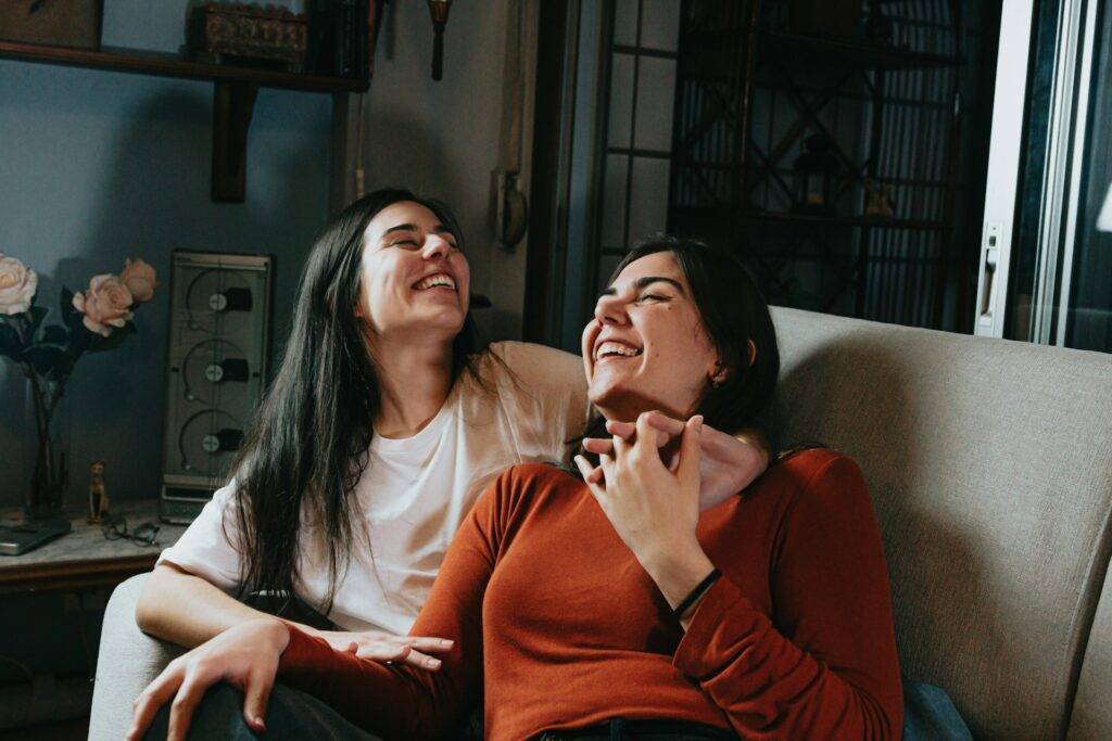 Two Women Laughing on a Couch