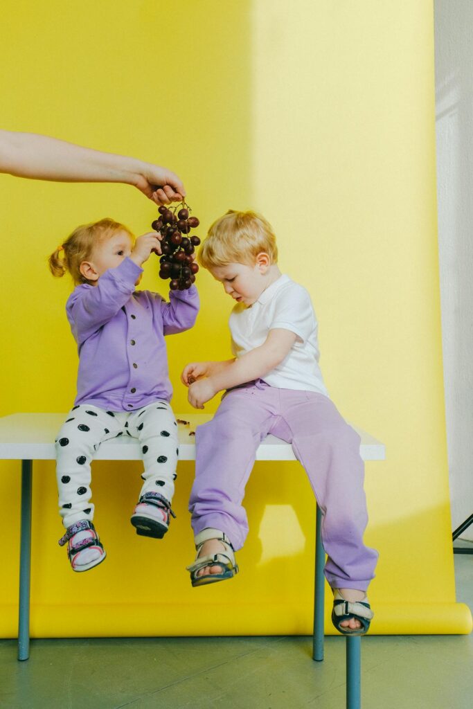 Two children eating grapes