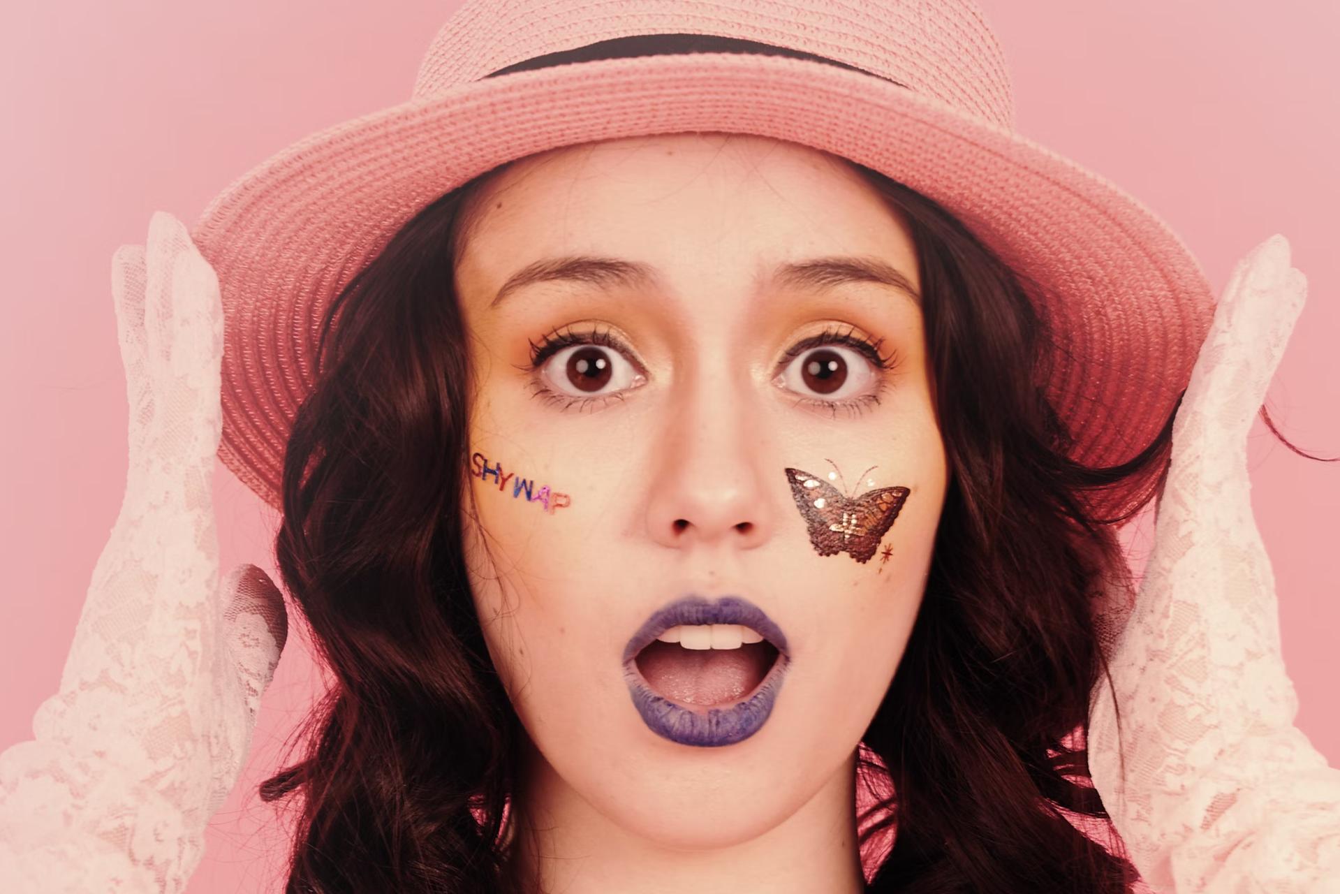 shocked woman with hat and face stickers