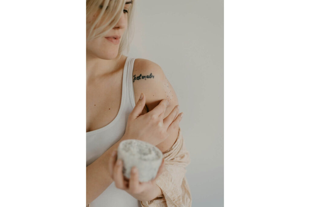A woman applying an exfoliating scrub to her arm
