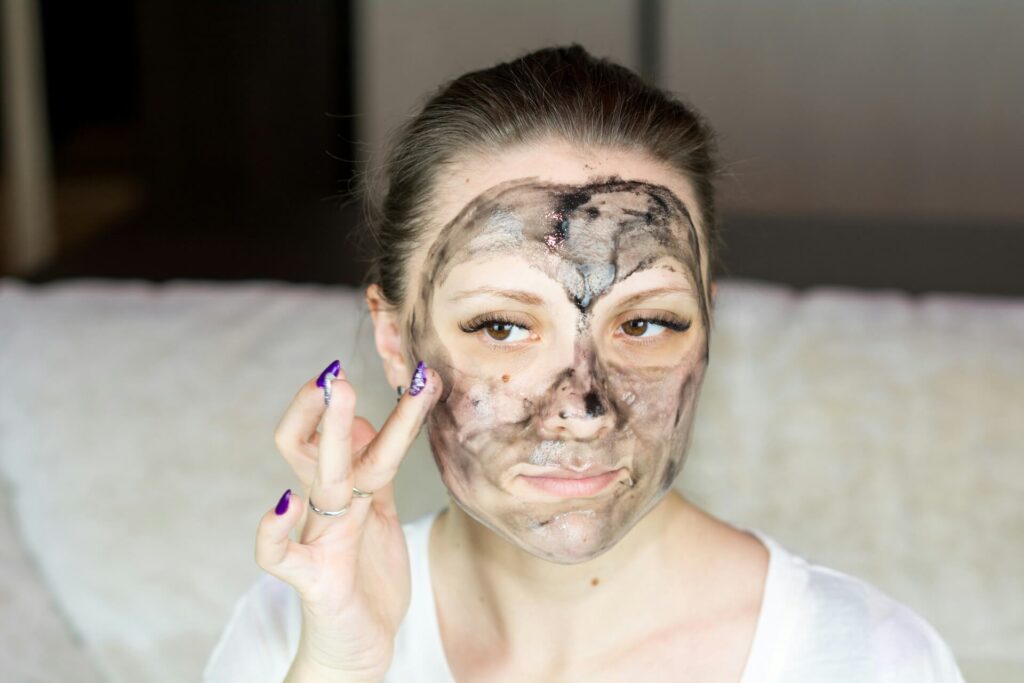 A woman applying a skincare mask to her face. 