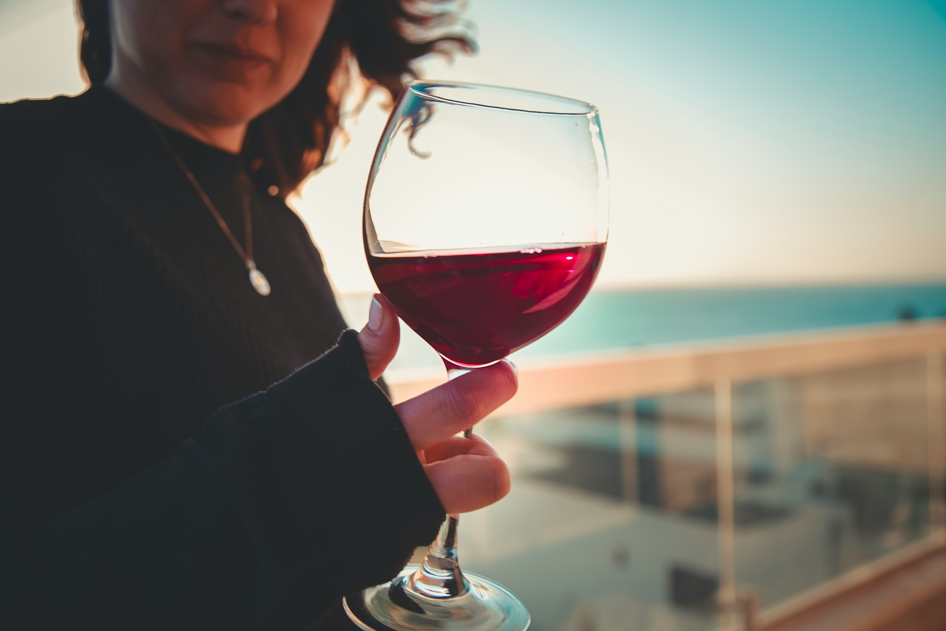 a woman holding a glass of red wine