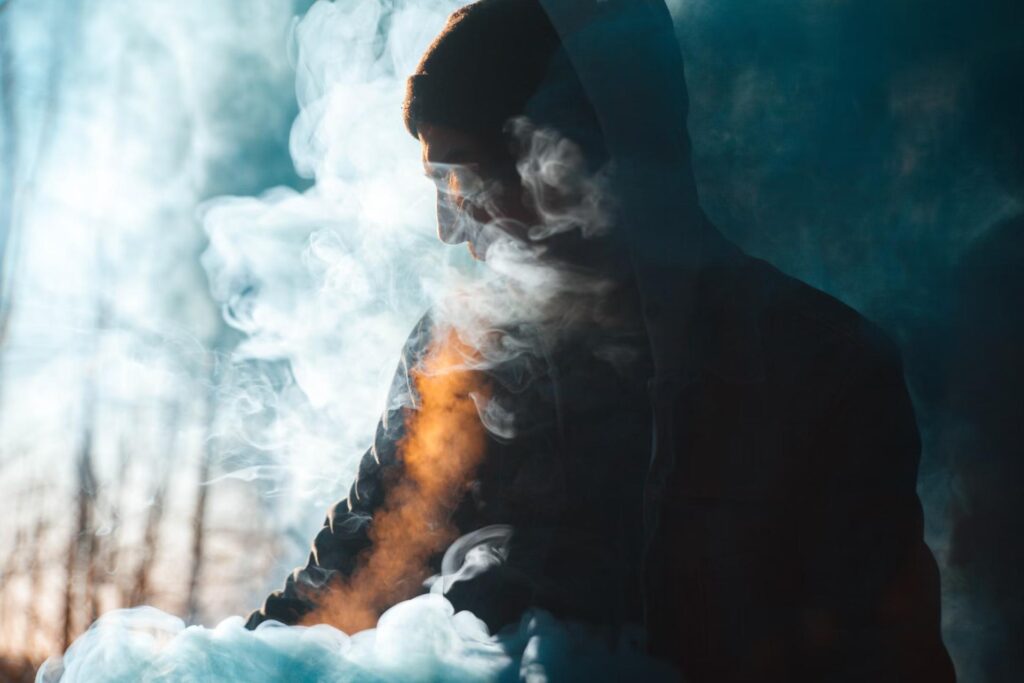 man with not top surrounded by smoke