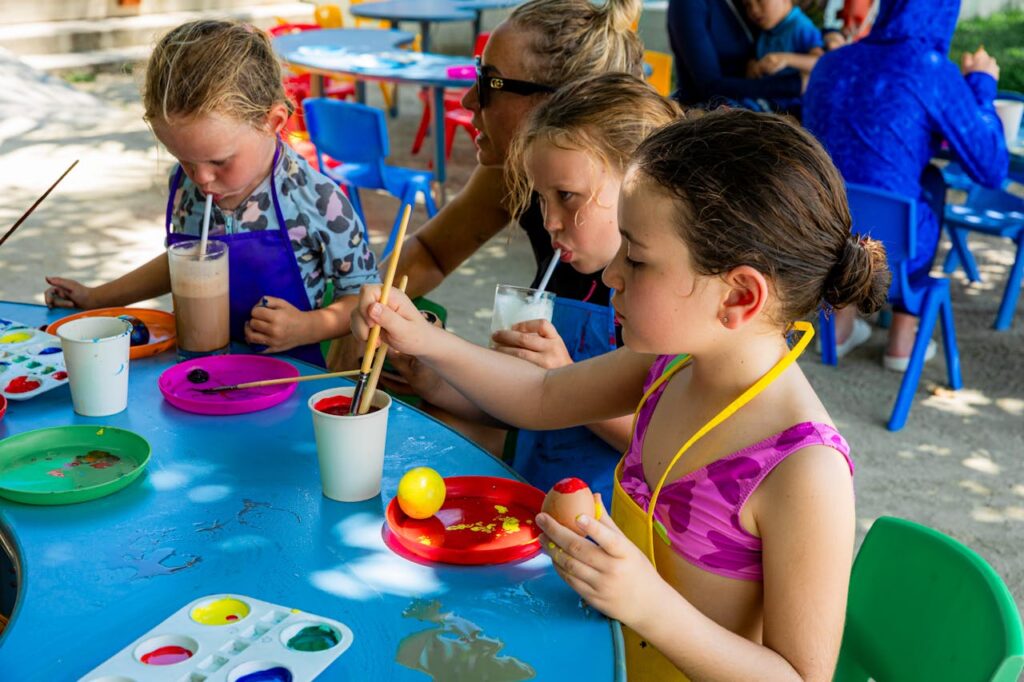 Children Painting and Enjoying Drinks Outdoors