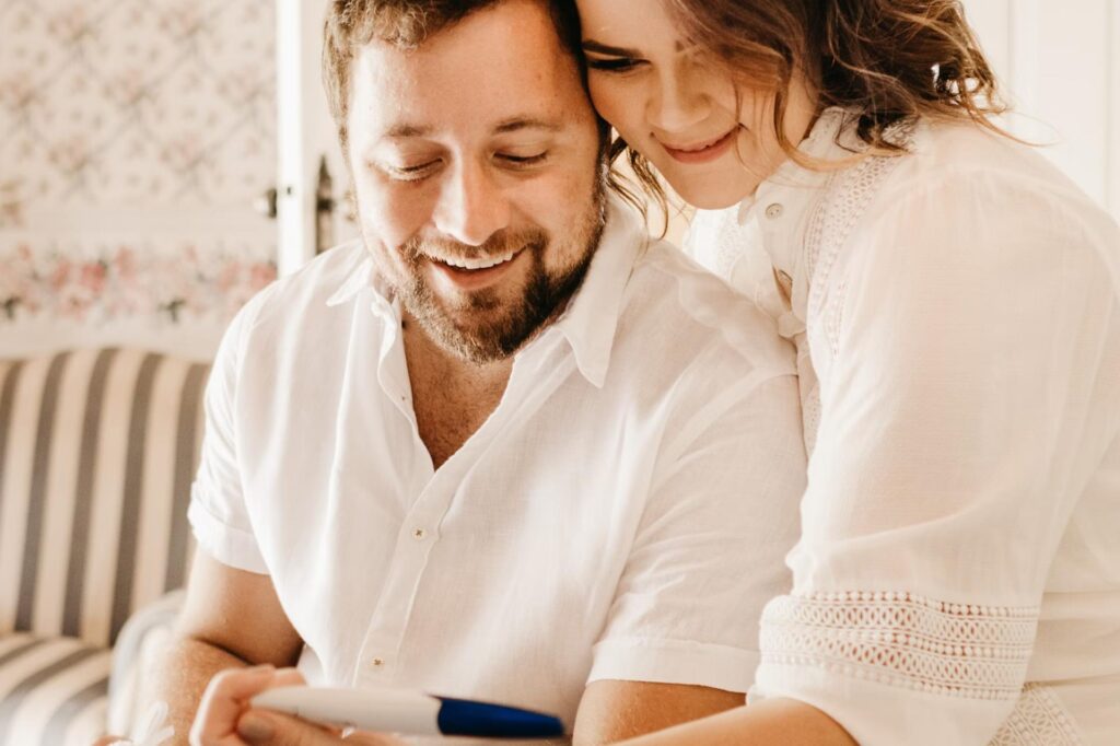 man and woman looking at pregnancy test